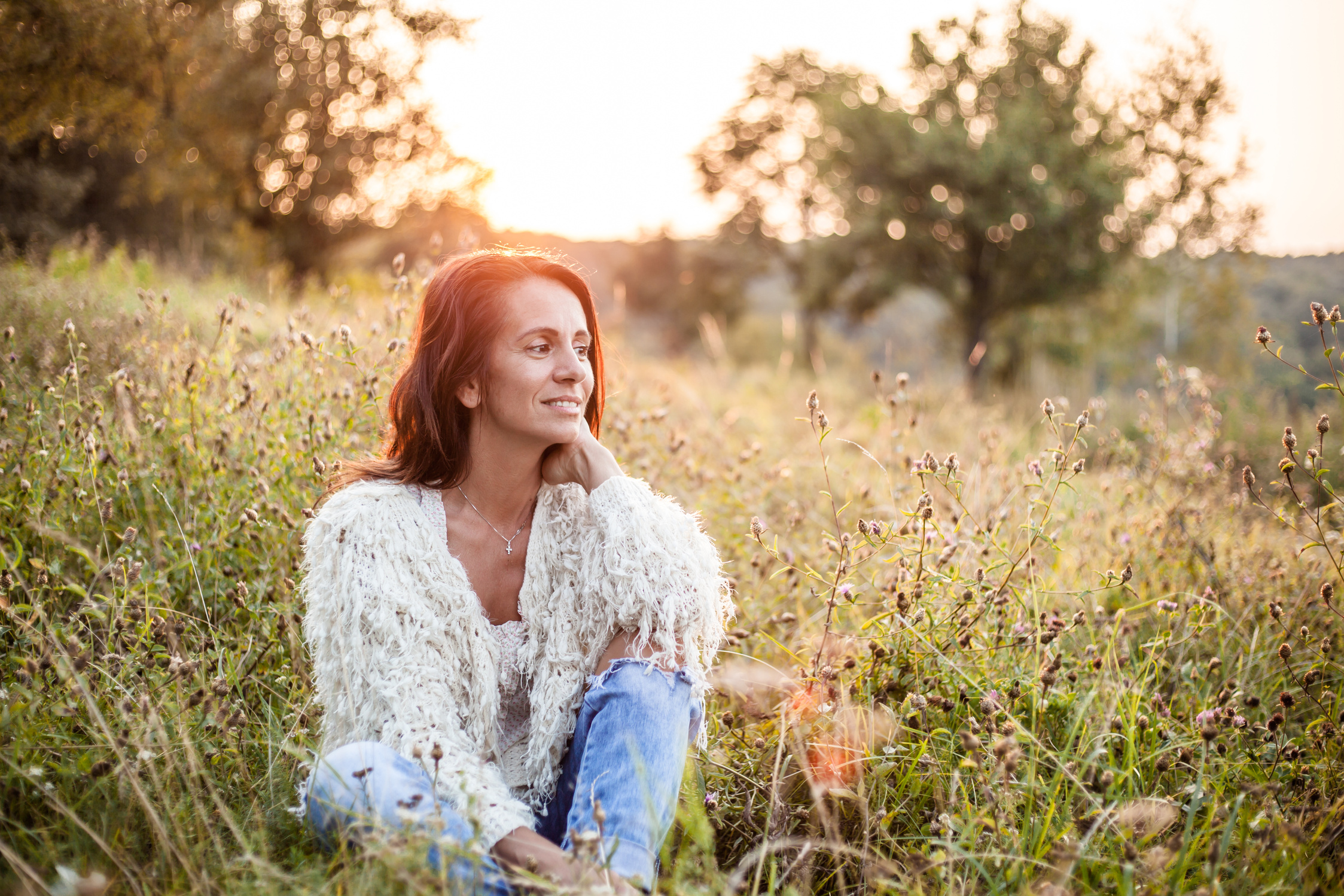 Portrait of a smiling mature woman sitting in the field